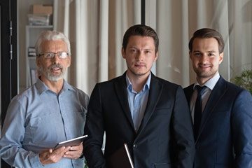 Drei Geschftsleute stehen zusammen.