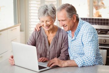 Älteres Paar schaut auf Notebook Maklerwebseiten an