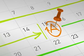 Ein Pin markiert einen Tag in einem Kalender